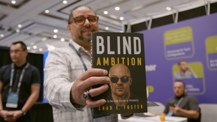 Chad E Foster with male client holding signed copy of Blind Ambition book