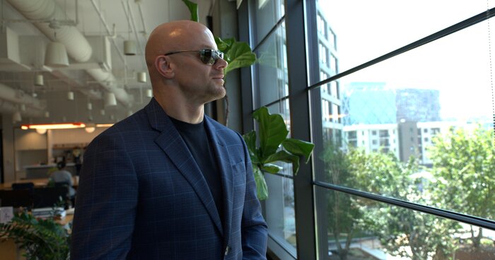 Medium portrait of Chad E Foster by window showing contemplative leadership